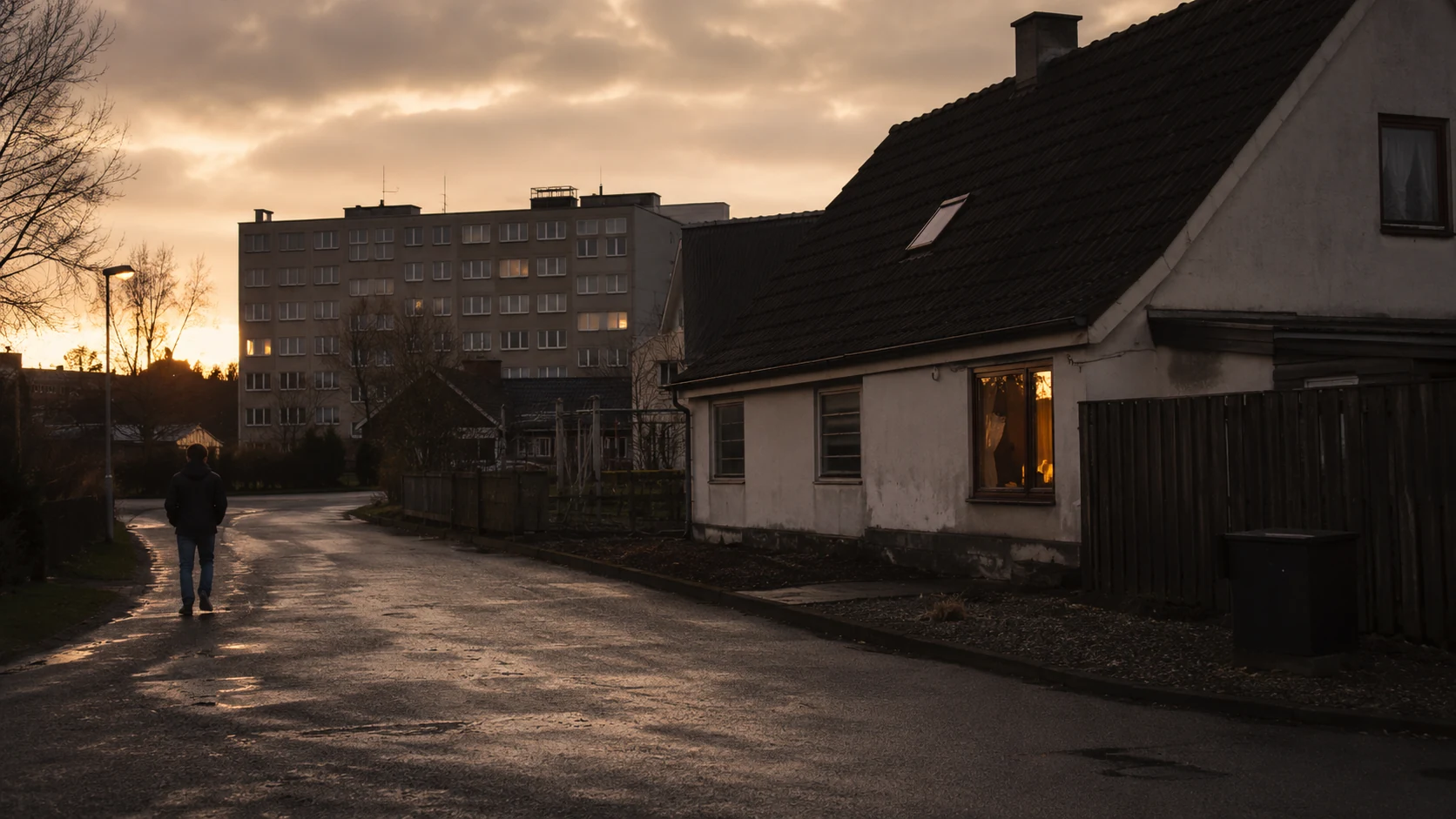 Regnvåd gade i et boligområde ved skumring